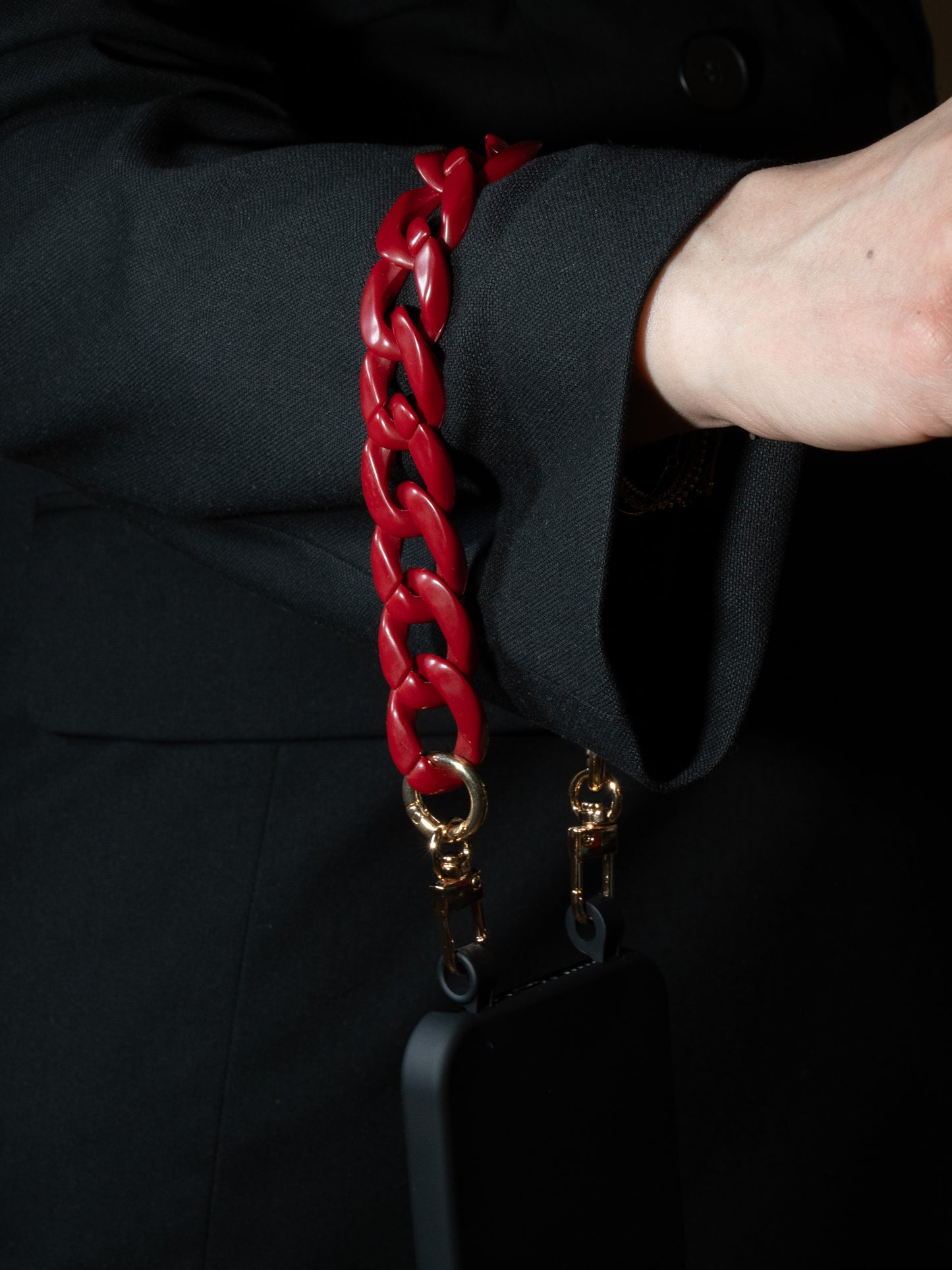 eleganter handykette in weinrot kurz um das Handgelenk