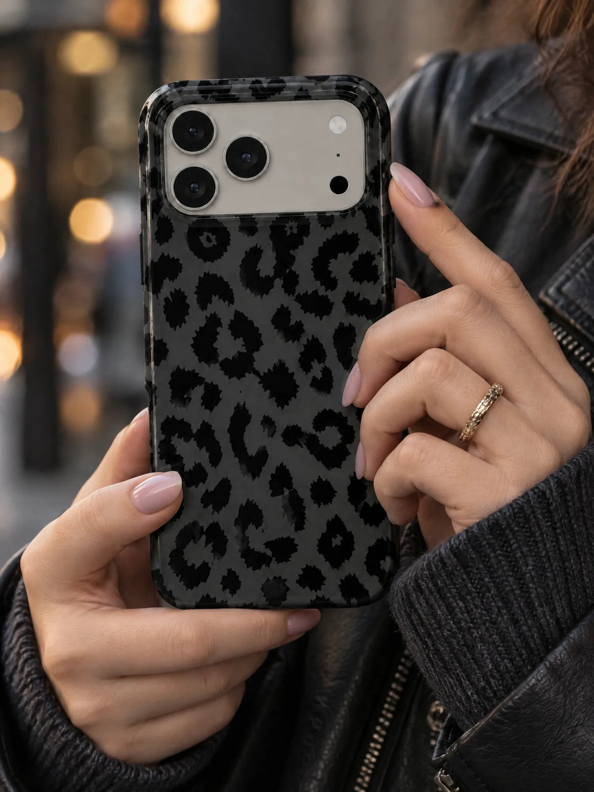 Leo Schwarz Handyhülle mit Öse — iPhone 14 Plus in der Hand