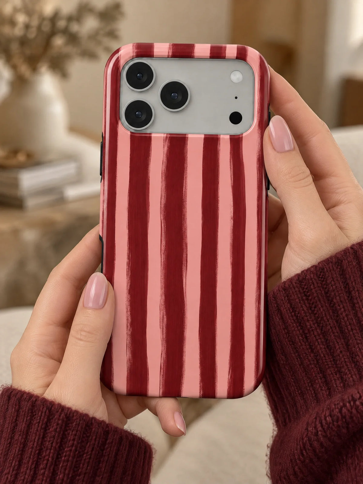 Streifen Bordeaux Handyhülle mit Öse — iPhone 16 in der Hand