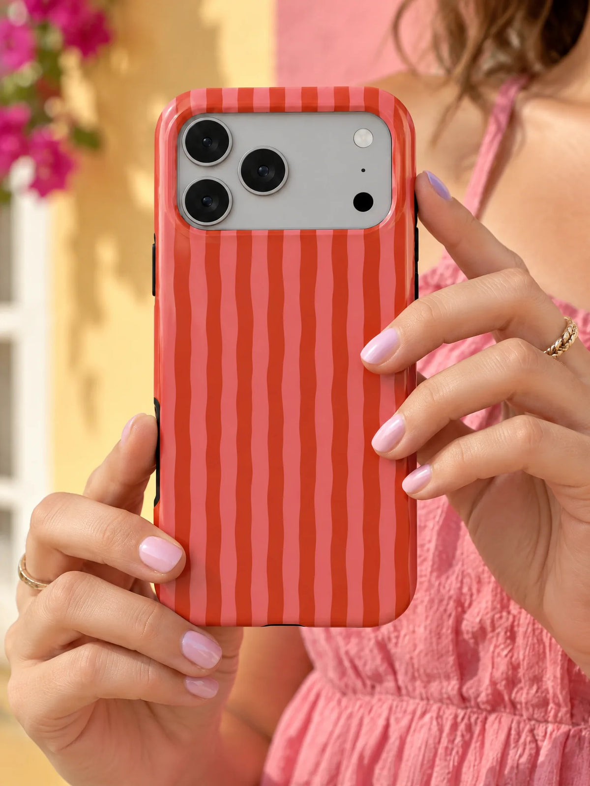 Streifen Rot-Rosa Handyhülle mit Öse — iPhone 15 Plus in der Hand
